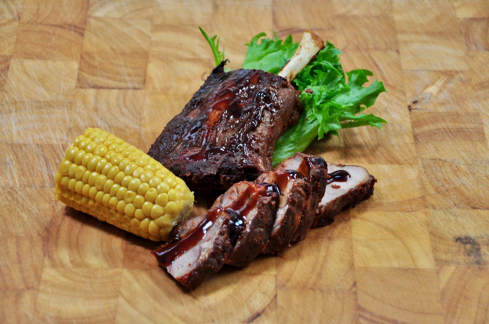 Grillet pig wing med maiskolbe på skjærebrett