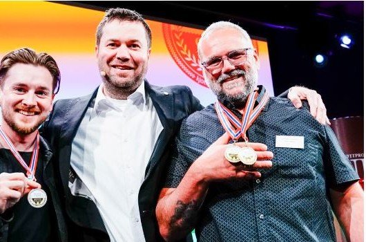 Fredrik Mydland og landbruks- og matminister Geir Pollestad med medaljer fra NM i kjøttprodukter 2024